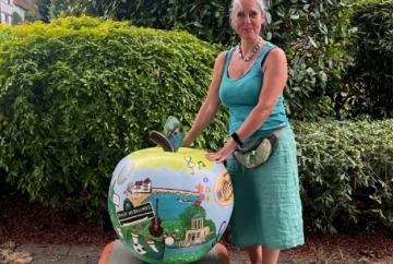 Artist repairs apple sculpture