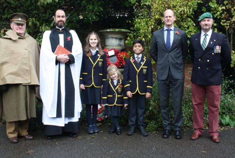 Children lay handmade wreaths at remembrance service in school grounds
